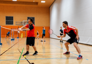 Badminton-Doppel im Hallenlicht