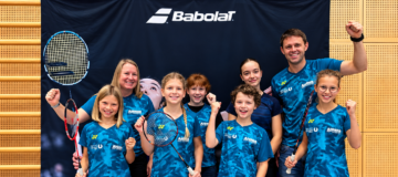 Badminton-Team feiert vor Babolat-Banner