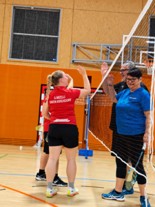 High-Five am Badmintonnetz in der Sporthalle